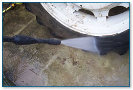 Cleaning farm machinery with pressure washer